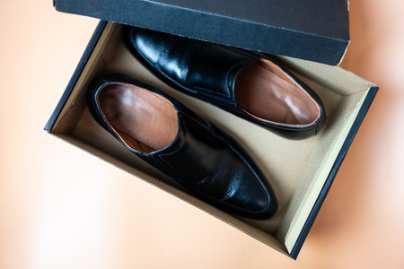 Male black leather shoe, new product on brown box, comfortable footwear for businessman or office workers. Open boxの写真素材