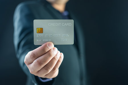 Businessman holding his white credit cardの写真素材