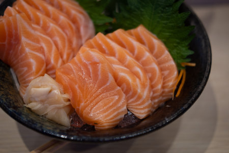 Premium sliced raw salmon or salmon sashimi in fresh Japanese style in black bowlの写真素材