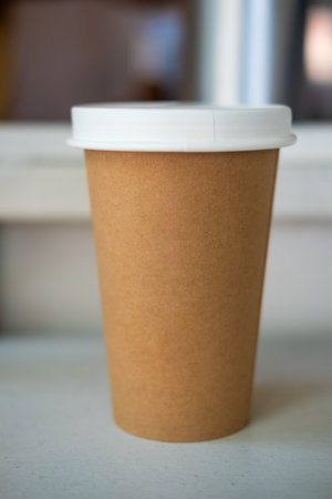 Brown paper cup with white lid of hot coffeeの写真素材