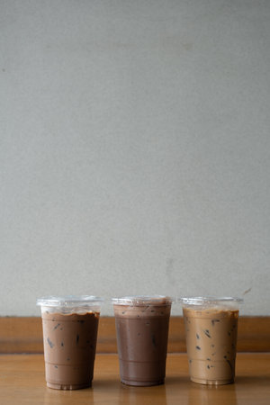 Take away plastic cup of iced chocolate, iced mocha and iced latte on table with copy space.の写真素材