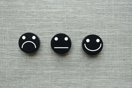 Happy, neutral and sad faces on black wooden blocks. Customer satisfaction or evaluation concept. Service rating and customer satisfaction conceptの写真素材