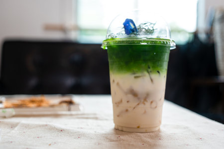 iced matcha green tea latte with milk layer in a take away glassの写真素材