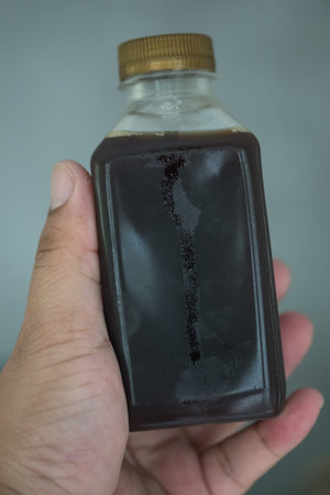 Male hand holding a bottle of cold brew coffee. Cold brewed drinks concept.の写真素材