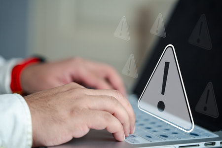 Businessman working on laptop computer, exclamation mark, alarm, warning, computer virus detected,...