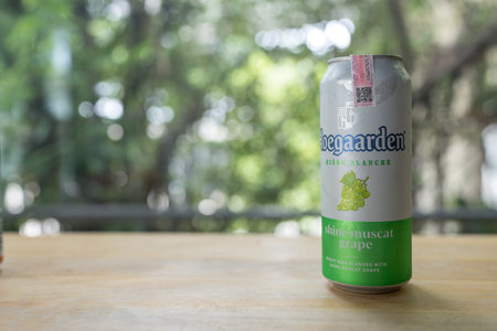 Bangkok, Thailand - June 23, 2024 : A can of Hoegaarden Shine Muscat Grape Belgium beer 500 ml size on wood table and against nature background.のeditorial素材