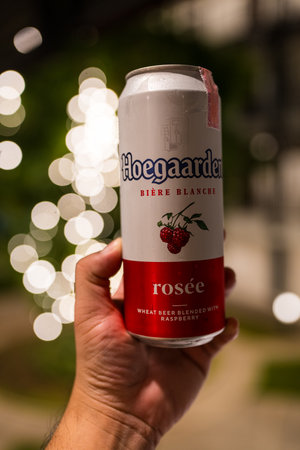 BANGKOK, THAILAND - JUNE 23, 2024 : Man hand holding a can of Hoegaarden Rosee Belgian beer with bokeh backgroundのeditorial素材
