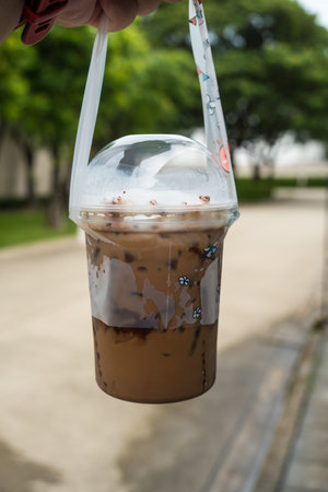 Man hand carrying bag of a cups of delicious iced cocoa. Close upの写真素材