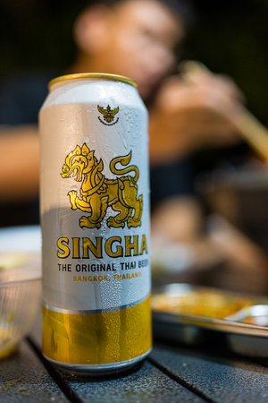 Bangkok, Thailand - June 23, 2024 : A Singha beer long can 490ml. put on the dinner table at campingのeditorial素材