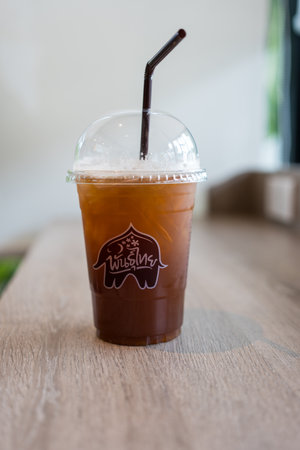 Bangkok - Thailand, July 5, 2024 : A plastic glass of iced tea at cafe Punthai Brand, coffee is a famous coffee company in Thailand.のeditorial素材