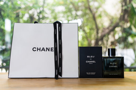 Bangkok, Thailand - July 5, 2024 : A paper bag, box and Bleu de Chanel for men on wood table. Parfume Bleu de Chanelのeditorial素材