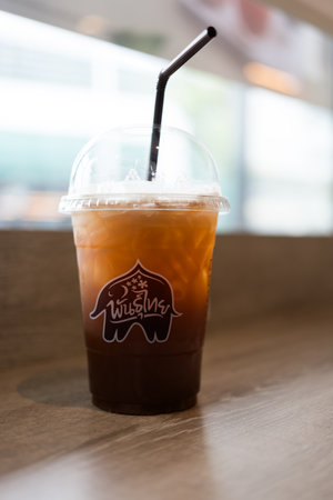 Bangkok - Thailand, July 15, 2024 : A plastic glass of iced tea at cafe Punthai Brand, coffee is a famous coffee company in Thailand.のeditorial素材