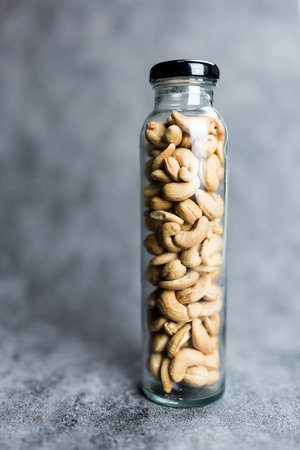 Cashews stored in a tall glass jar, this nutritious snackの写真素材