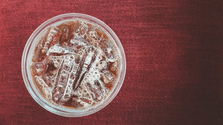 Closeup top view ice of americano on red sofaの写真素材