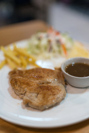 Deliciously fragrant pork steak served with salad, french fries and dipping sauce. Selective focusの写真素材
