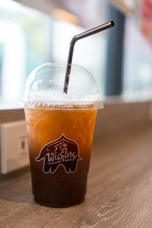 Bangkok - Thailand, July 22, 2024 : A plastic glass of iced tea at cafe Punthai Brand, coffee is a famous coffee company in Thailand.のeditorial素材