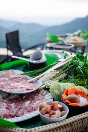 Thai barbecue with fresh vegetables and sliced ââpork with the mountain and natural view in a restaurant in the mountainsの写真素材
