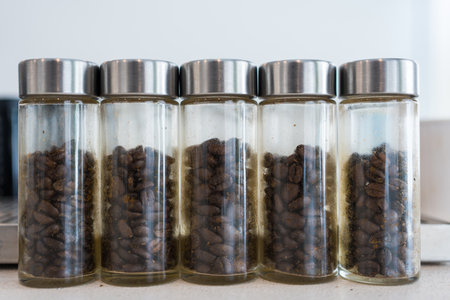 A row of coffee beans in glass jar on coffee shop counterの写真素材