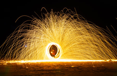 Swing fire dancing show, long exposure on the floor at the night time in the beach at Thailand