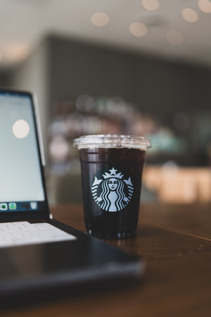 Bangkok, Thailand - September 2, 2024 : Starbucks iced cold brew coffee and computer at Starbucks...