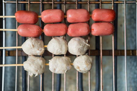 Grilling sausage, and meatballs on the stove. BBQ party style.の写真素材