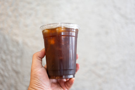 Hand holding a glass of iced black coffee in the morning.の写真素材