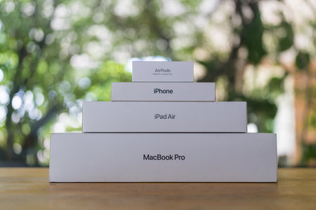 Bangkok, Thailand - September 16, 2024 : Boxes from Apple placed like a pyramid include Macbook Pro, iPad Air, iPhone, and AirPods against nature background. The concept of Apple company devices.のeditorial素材