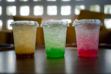 Colorful Italian soda in a plastic cup on the table in summerの写真素材