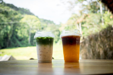 Black coffee separate layer with orange juice and green tea separate layer with fresh milk. Summer cold drinkの写真素材