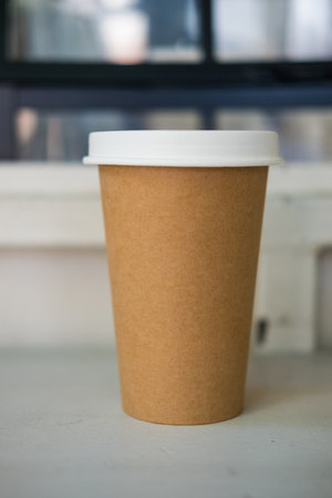 A brown paper cup with white lid for hot drinkの写真素材