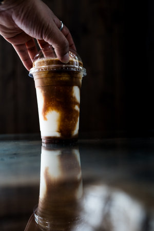 Man put a cup of fresh and delicious ice blended coconut coffee in the cafeの写真素材