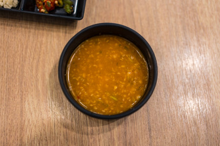 Sukiyaki dipping sauce with white sesame in black bowlの写真素材