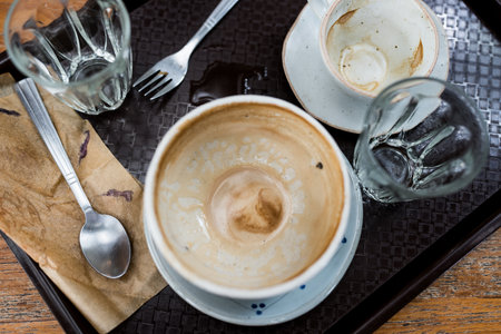 Empty coffee cup after drink on a wooden table. Concept for ending a meeting or something else. Cafe culture.の写真素材