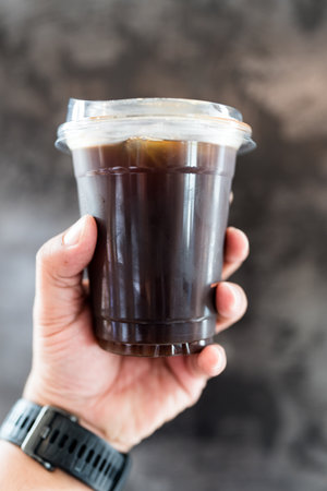 Iced americano in hand. The refreshing moment of enjoying a cold coffee drinkの写真素材