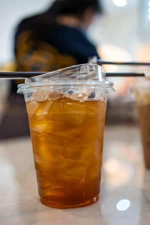 Glass of tasty lemon iced tea on wood table at cafeの写真素材