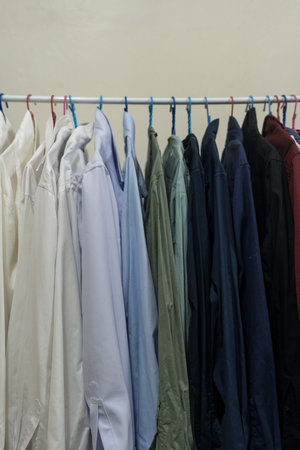 Minimal rack male clothes on hangers. In closet, dressing room for wardrobe at bachelor's apartment interior. Man outfits store.の写真素材