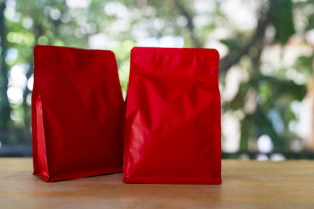 Roasted coffee in red zipper bag against nature background.の写真素材