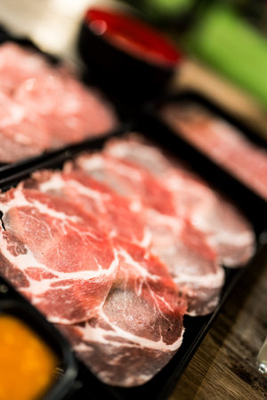 Pieces of raw meat thin sliced ingredients for hotpotの写真素材