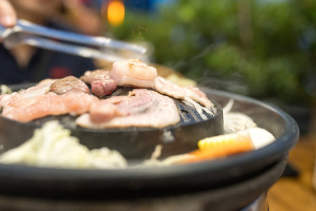 Thai style barbecue. It is the popular food in Asia by grill the pork, meat or sea food on the hot pan that can put the soup of vegetable around a pan too. Thai barbecue grill Pork on hot pan buffet.の写真素材
