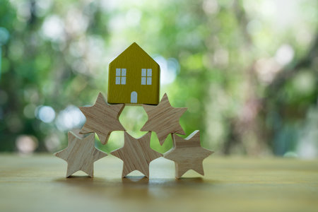 Wood home placed on top of five wood star. Reviews of real estate and residences concept.の写真素材