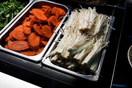 Raw of slice carrot and raw golden needle mushroom in stainless steel tray in buffetの写真素材