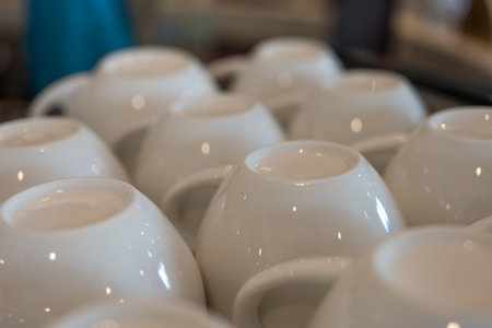 Ceramic coffee cups lie upside down on a coffee machine in a cafeの写真素材