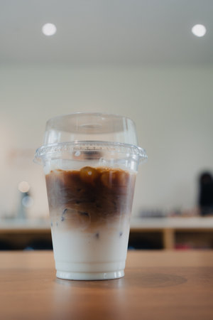 Iced coffee latte served on the wooden table in coffee shopの写真素材