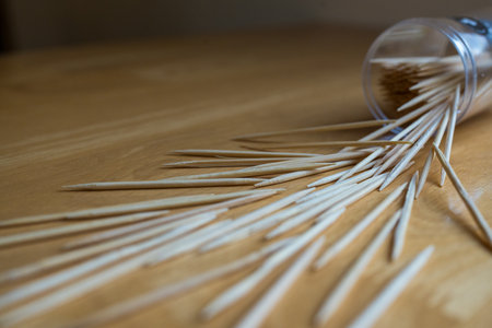 Close up of toothpicks spread on floor from a clear plastic holderの写真素材