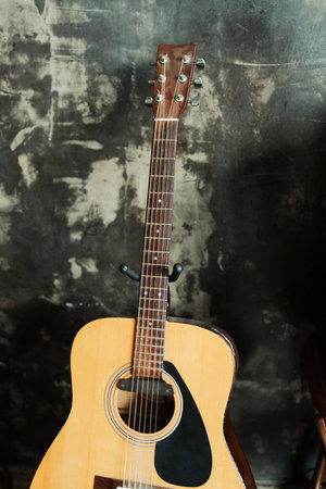 Acoustic guitar standing on a loft cement wall backgroundの写真素材