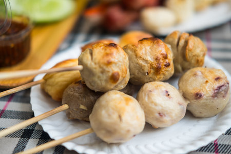 Thai street food. Meatballs on sticks served on white dishの写真素材