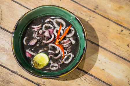 Squid black soup in green bowl. Local food in eastern Thailandの写真素材