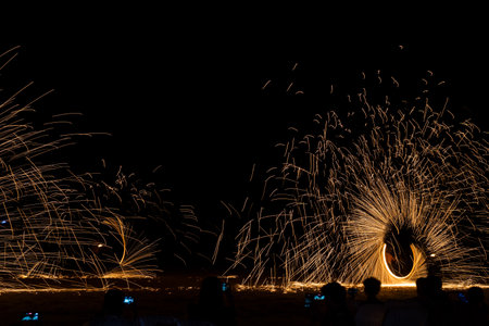 Swing fire dancing show, long exposure on the floor at the night time in the beach at Thailandの写真素材