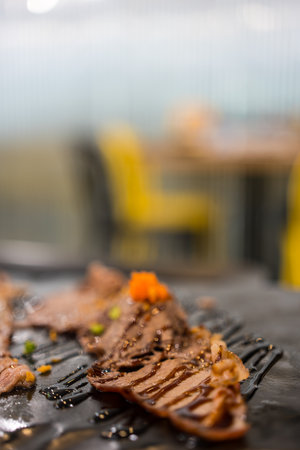 Sliced beef with garnish served at a fine dining restaurant. Close up