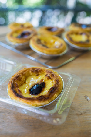 baked egg tart dessert put in box on wood table